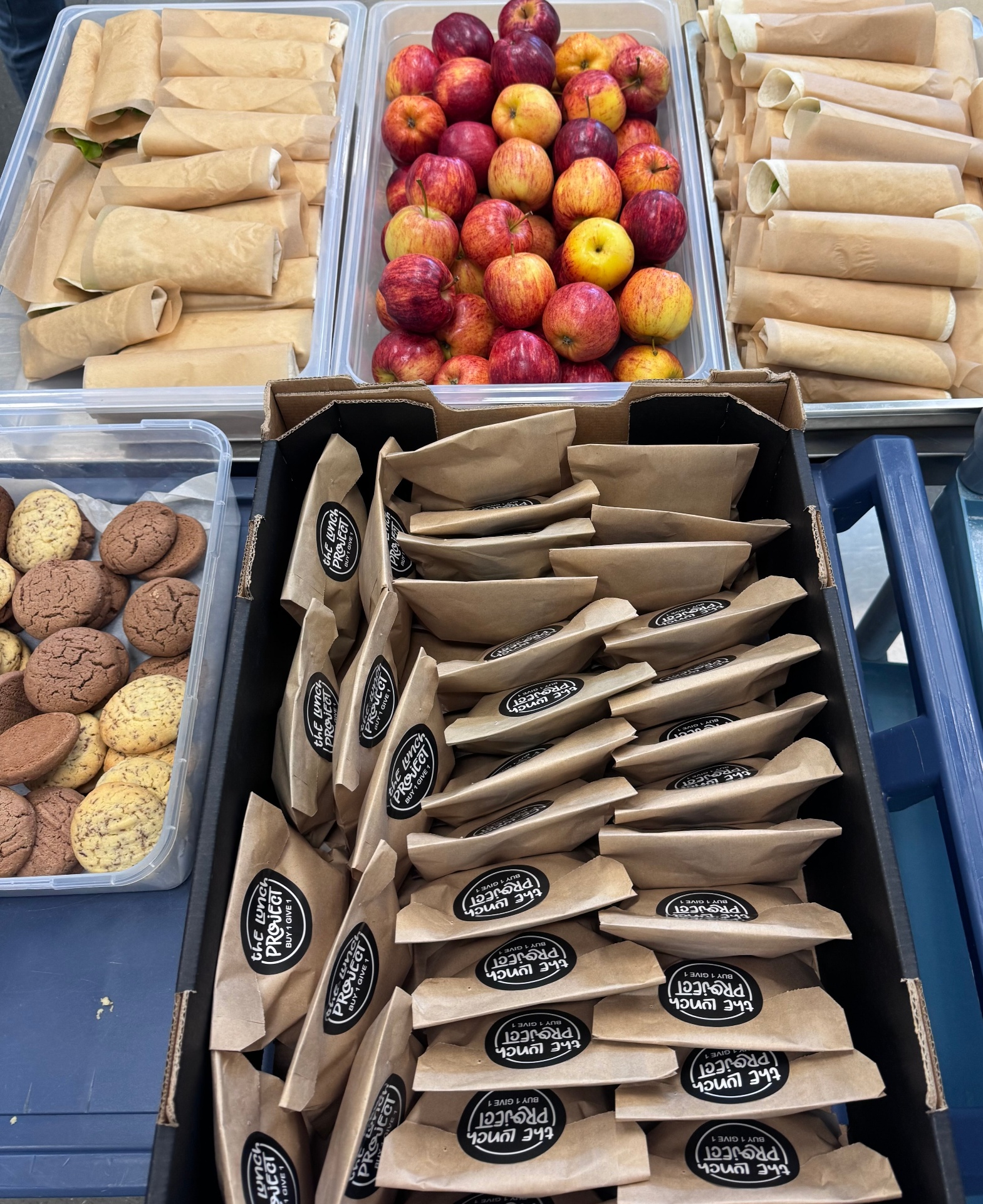 Freshly packed Lunch Project bags with apples, wraps and cookies ready for delivery